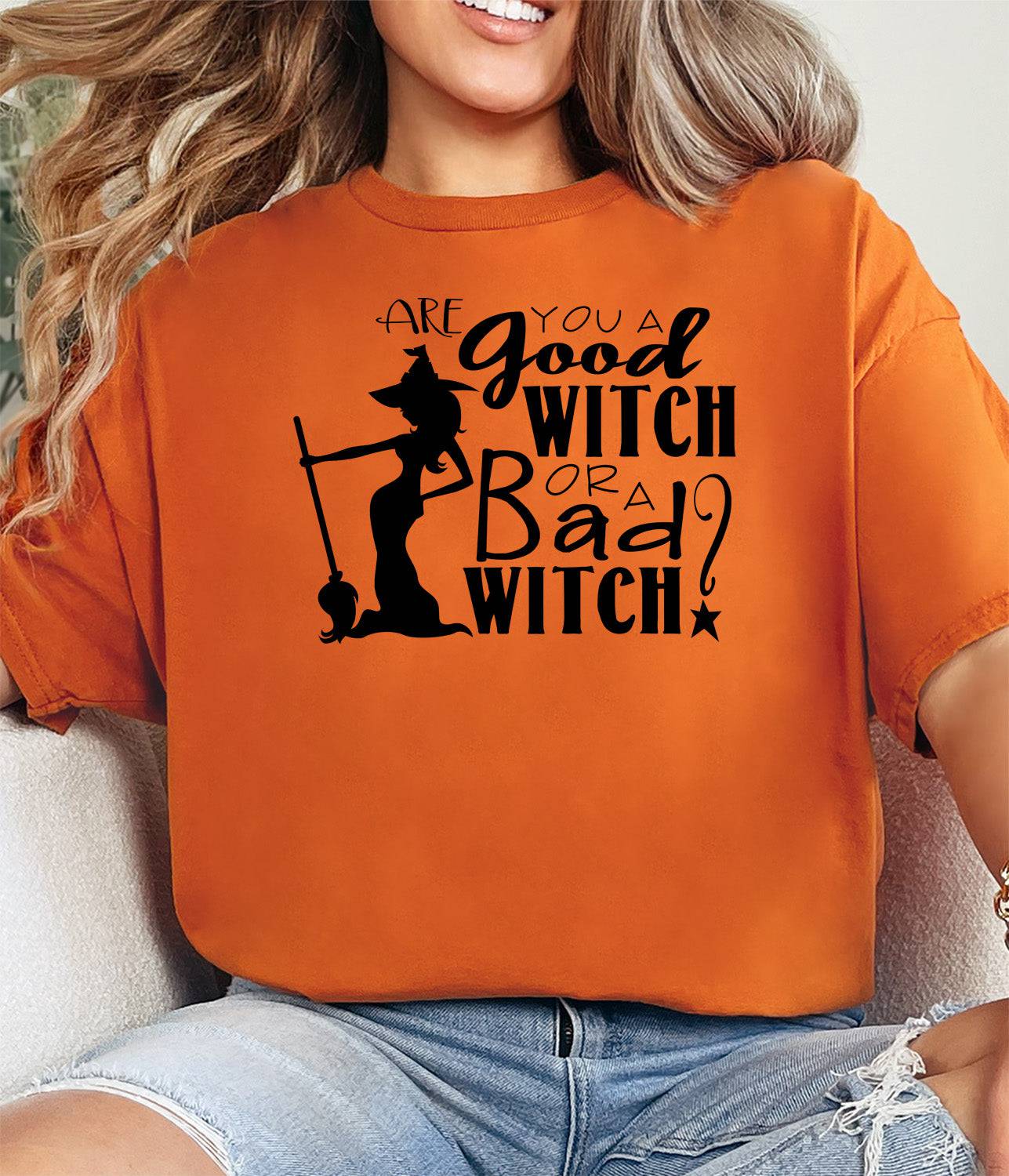Woman wearing a burnt orange Are  You a Good Witch or a Bad Witch t-shirt.