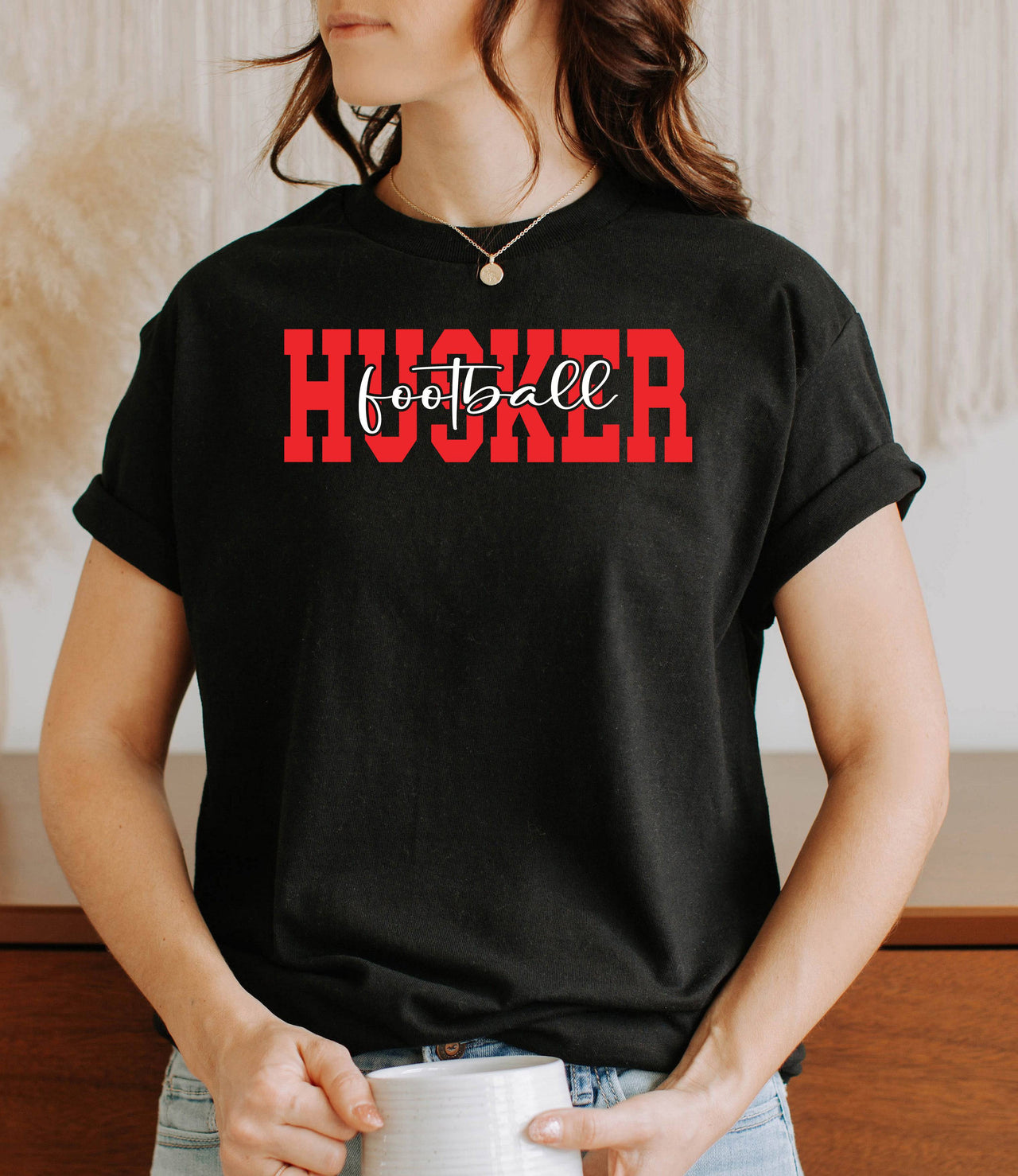 Woman wearing a black Husker football lt-shirt.