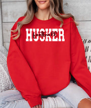 A woman wearing a red Husker Football crewneck sweatshirt.