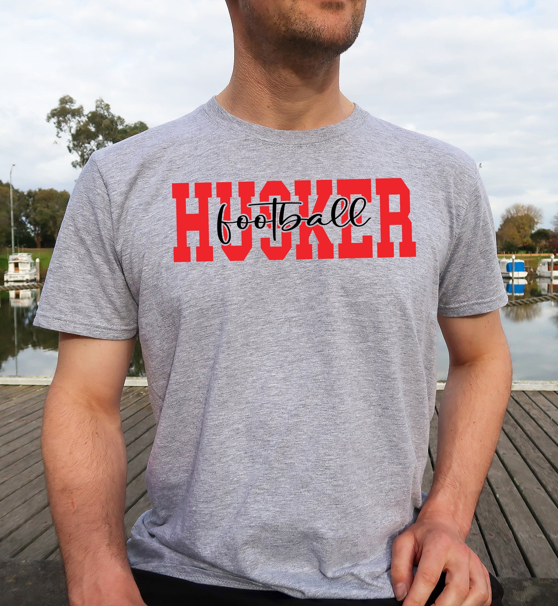 Man wearing a sport grey Husker Football t-shirt.