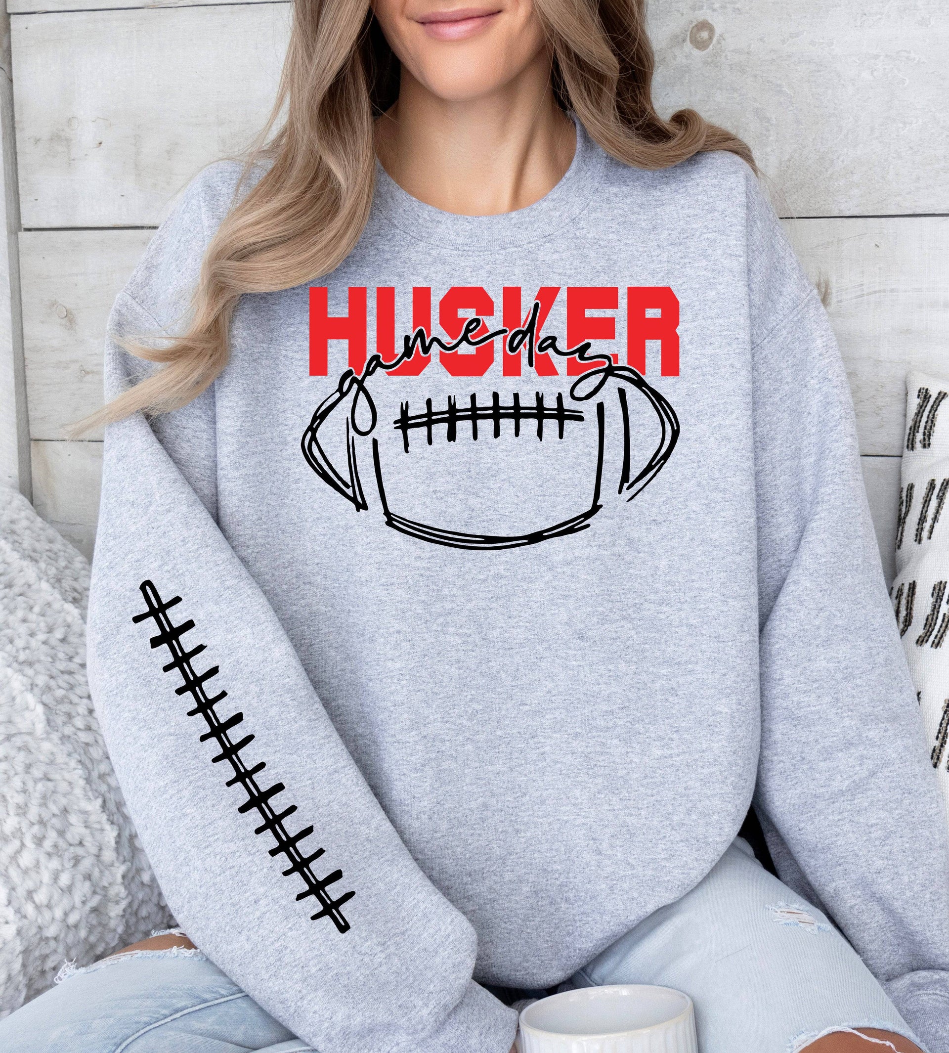 Woman wearing a sport grey Husker Game Day crewneck sweatshirt.