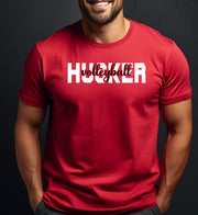 Man wearing a red t-shirt with 'Husker Volleyball' text on a dark background