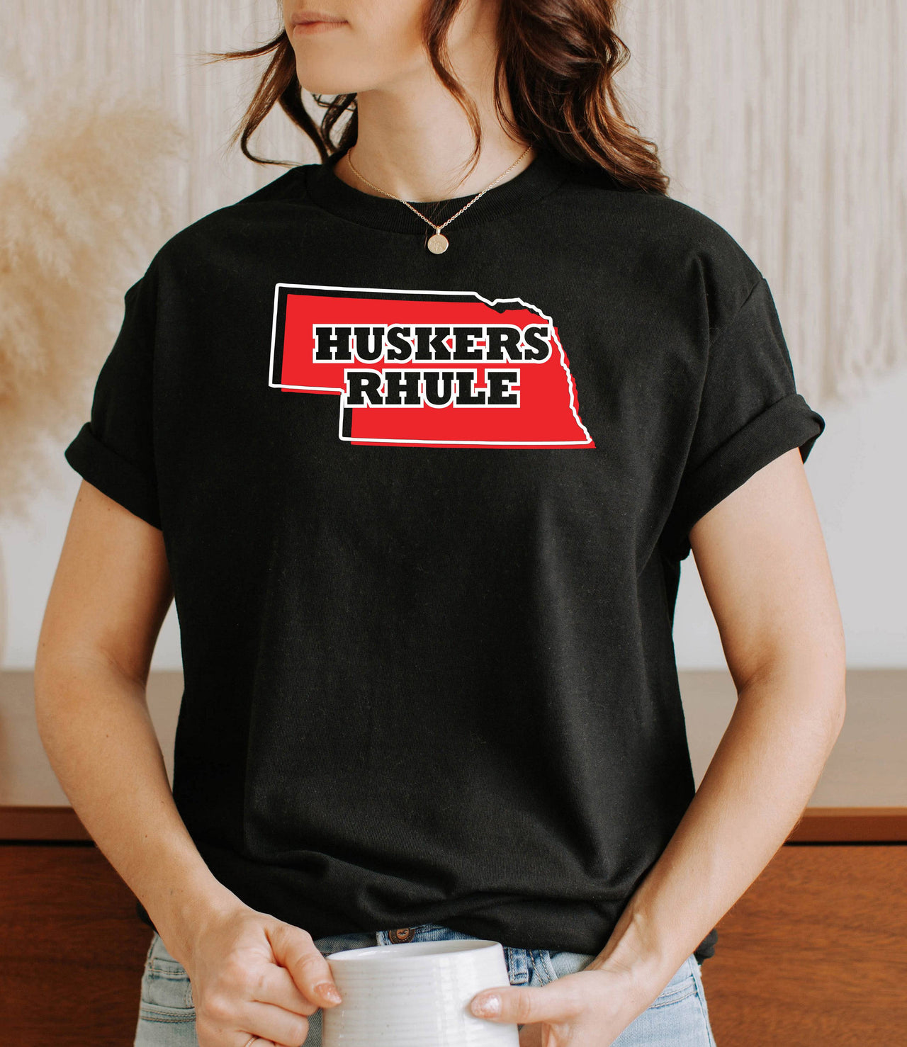 Woman wearing a black Huskers Rhule t-shirt.
