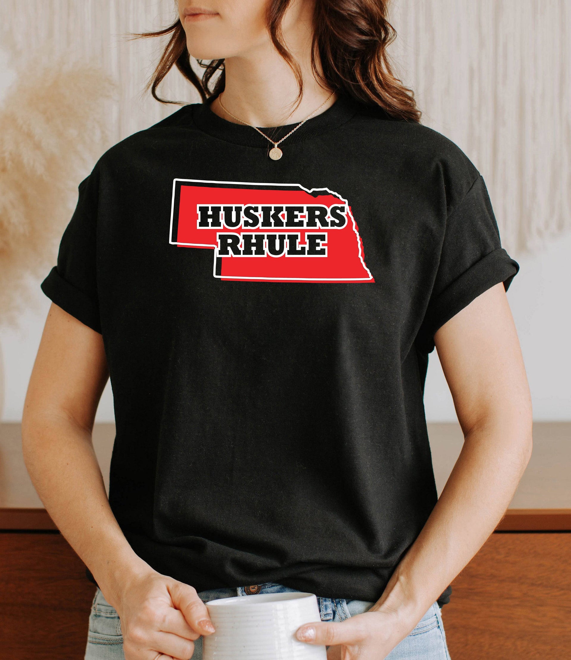 Woman wearing a black Huskers Rhule t-shirt.