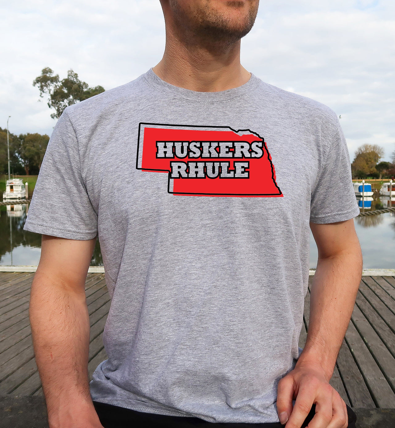 Man wearing a sport grey Huskers Rhule t-shirt.