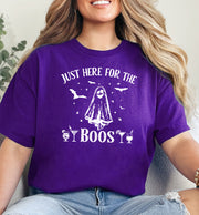 A person wearing a purple t-shirt with 'I JUST HERE FOR THE BOOS' text and a graphic of a ghost on the front.