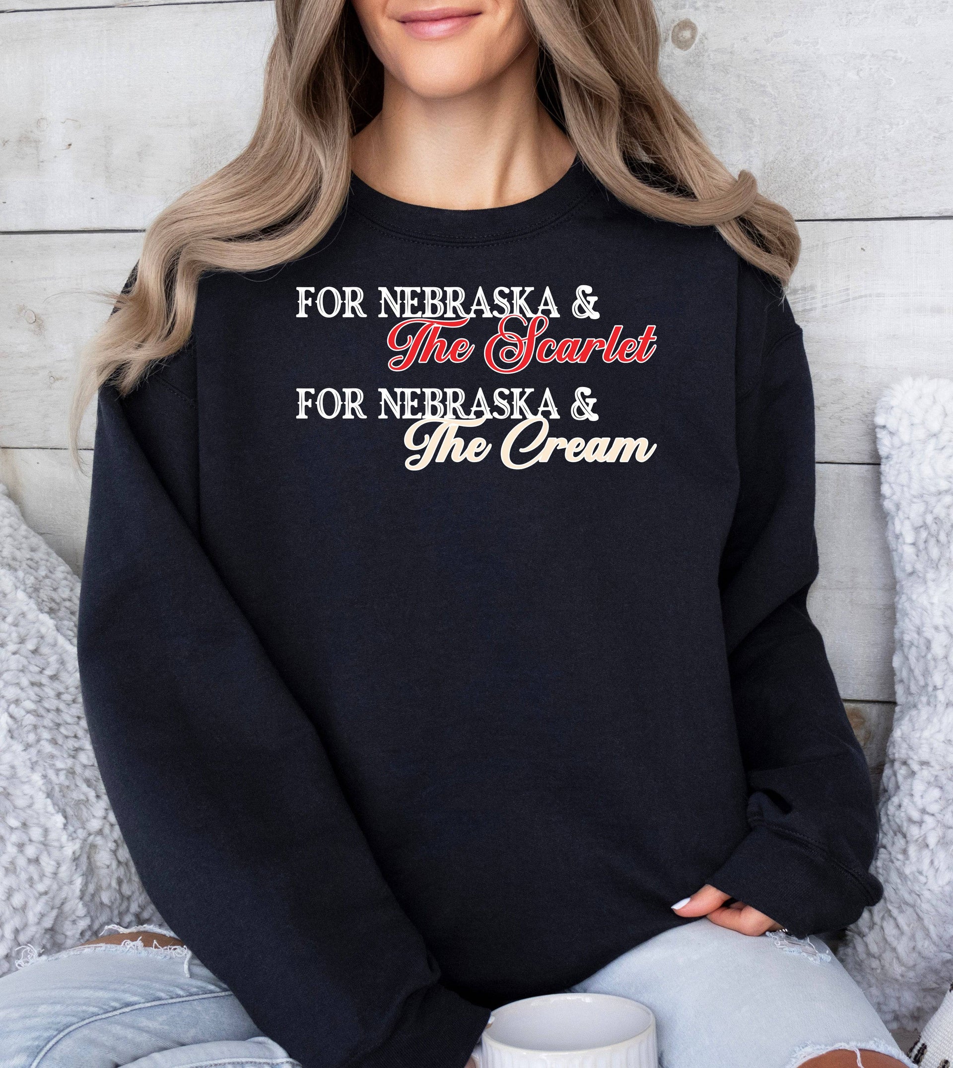 Woman wearing a black Scarlet and Cream crewneck sweatshirt.