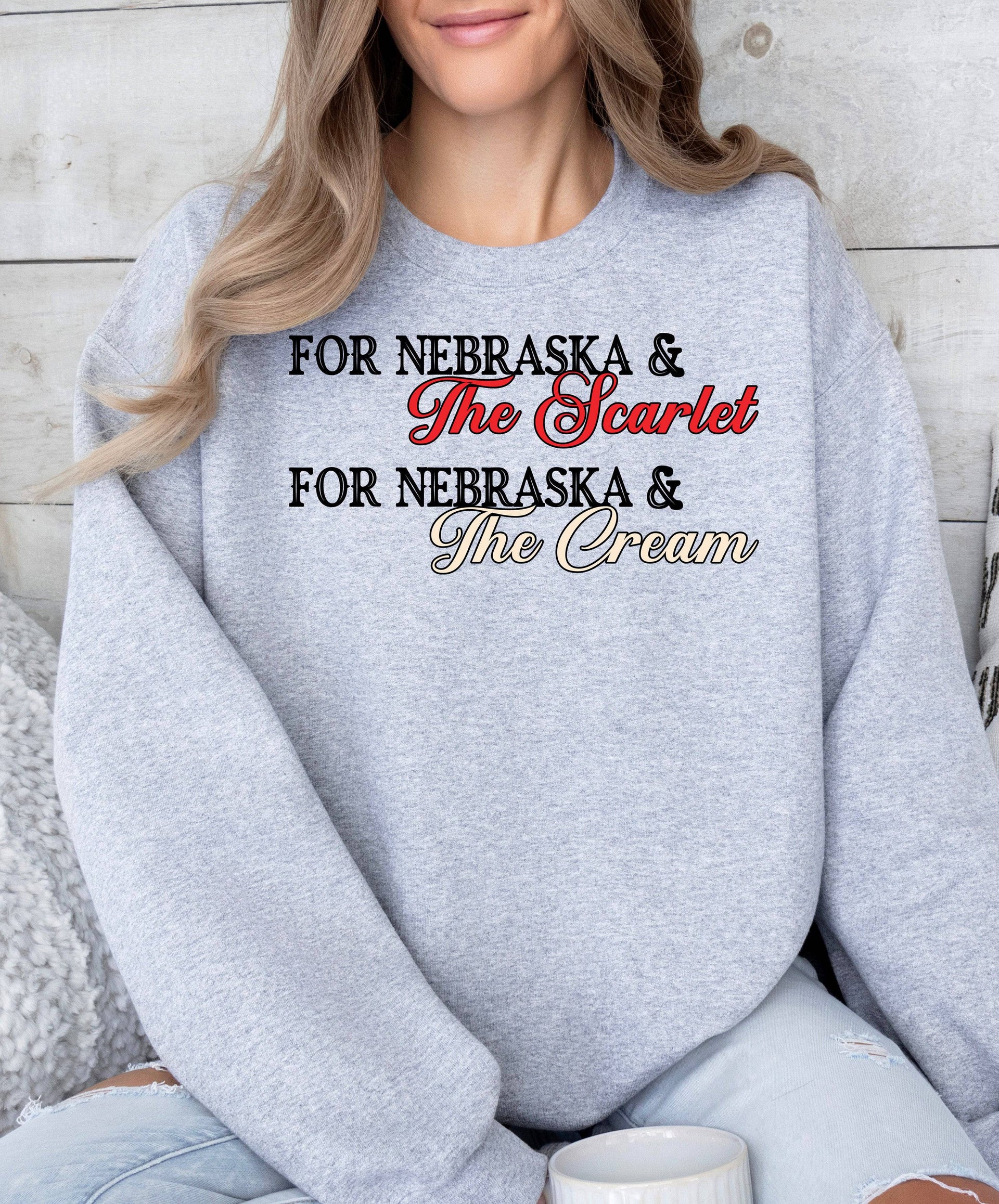 Woman wearing a sport grey Scarlet and Cream crewneck sweatshirt.