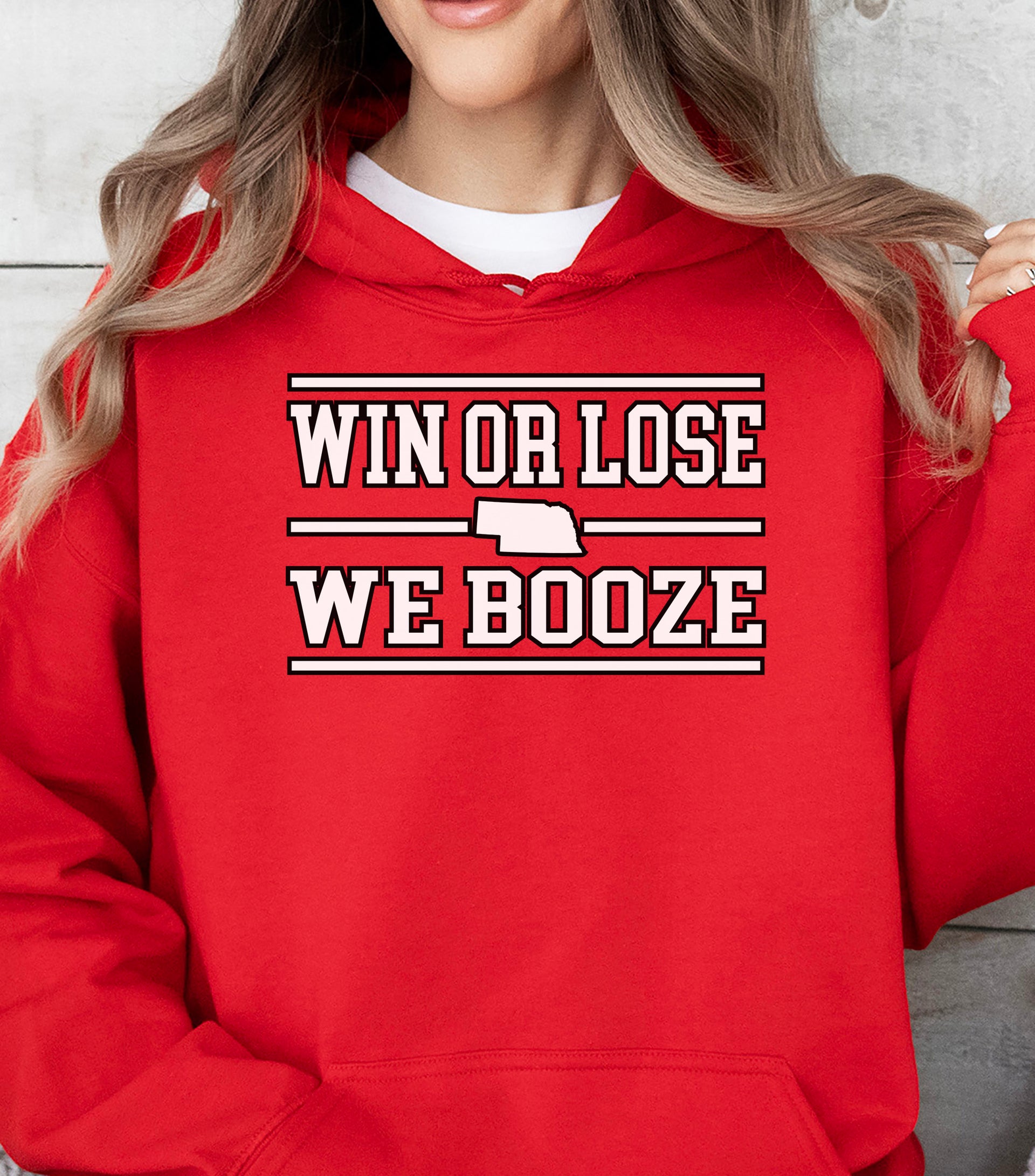 Red hoodie with 'Win or Lose, We Booze' text worn by a person