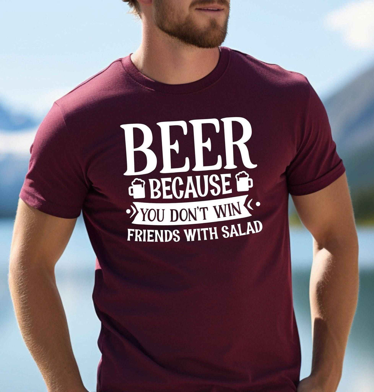 Man wearing a maroon Beer Because You Don't Win Friends With Salad graphic T Shirt featuring bold white lettering and beer mug illustrations.