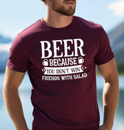 Man wearing a maroon Beer Because You Don't Win Friends With Salad graphic T Shirt featuring bold white lettering and beer mug illustrations.