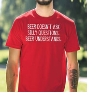 Man wearing a red graphic T Shirt with white lettering reading Beer Doesn't Ask Silly Questions Beer Understands, a funny beer lover design.
