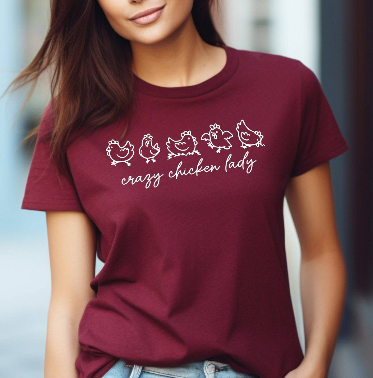 Woman wearing a Maroon Crazy Chicken Lady graphic T Shirt featuring five white chicken illustrations and script lettering, perfect for backyard chicken keepers.
