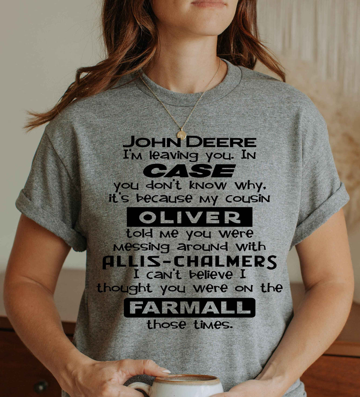 Woman wearing a graphite grey graphic T Shirt featuring a funny tractor-themed saying with John Deere, Case, Oliver, Allis-Chalmers and Farmall tractor brands.