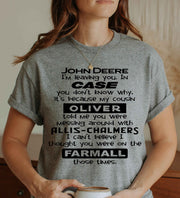 Woman wearing a graphite grey graphic T Shirt featuring a funny tractor-themed saying with John Deere, Case, Oliver, Allis-Chalmers and Farmall tractor brands.